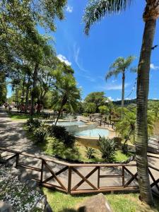 un parco con piscina, alberi e recinzione di Casa das Bromélias- Com Quiosque em meio à natureza! a Piratuba