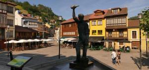 a statue in the middle of a town with buildings at De la Cuenca Mieres II con parking Privado in Mieres