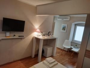 a small room with a desk and a tv on a wall at Room No3 in Trogir