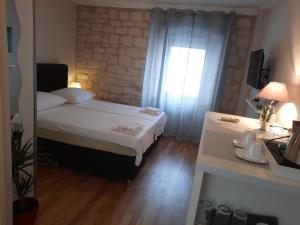 a small bedroom with a bed and a window at Room No3 in Trogir