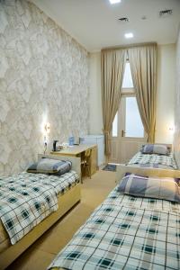 Cette chambre comprend 2 lits et un bureau. dans l'établissement YUKSALISH HOSTEL, à Samarcande