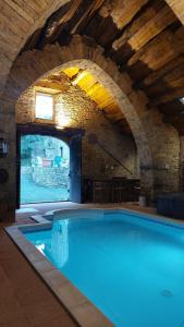 - une grande piscine dans un bâtiment avec une arche dans l'établissement Gîtes la Molière Haute, à Plaisance