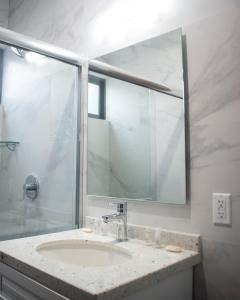 een badkamer met een wastafel en een glazen douche bij Hotel Manadia in Tequila