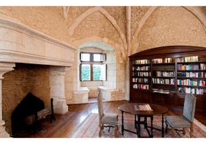 uma sala com lareira e uma mesa numa biblioteca em Hapimag Château de Chabenet em Chabenet