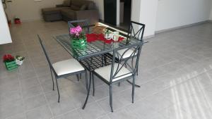 - une table en verre avec 2 chaises et des fleurs dans l'établissement Montalbano Sweet Home, tra l' Etna e il mare, à Fleri