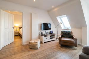 a living room with a couch and a chair and a television at Weisse Villa Apartment 3 1 Hafenkante in Büsum