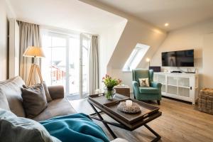 a living room with a couch and a table at Weisse Villa Apartment 3 2 Annis Strandnest in Büsum