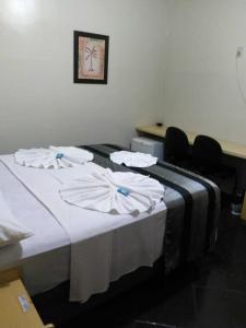a hotel room with two beds with white sheets at Klinn Hotel in Tanabi