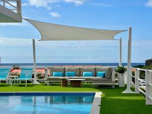a gazebo with chairs and a table next to a pool at Apartment in luxury villa with private pool in Willemstad