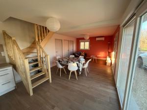 a dining room with a table and chairs and a staircase at SCI BSA Magnifique maison au calme in Les Essards-Taignevaux