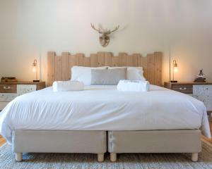 a bedroom with a large white bed with two pillows at Quinta de Carcavelos Natures Home in Amarante
