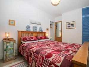 a bedroom with a bed with a red and white bedspread at Solent Sea View in Fareham