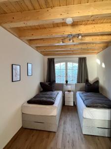 two beds in a room with wooden ceilings at Ferienwohnung Blick Thyratal in Stolberg