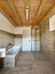 a bathroom with a tub and a glass shower at Ferienwohnung Blick Thyratal in Stolberg