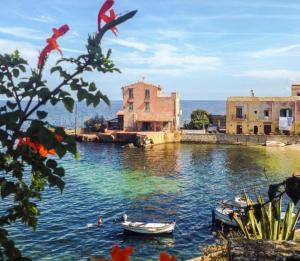 una masa de agua con edificios y barcos en ella en Da Carmen e Peppe, en Santa Flavia