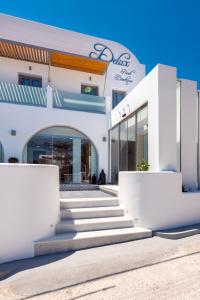 a white building with stairs in front of it at Deluxe Hotel Santorini in Fira