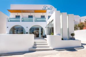 a white building with stairs in front of it at Deluxe Hotel Santorini in Fira