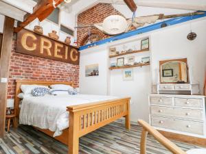 a bedroom with a bed and a brick wall at Cowes View Cottage in Fareham