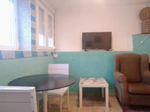 Una habitación con una mesa y una silla y un televisor. en Santa Clara, en Almería
