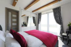 a bedroom with a bed with a red blanket on it at Lotti Residence Exclusiv in Balatonfüred