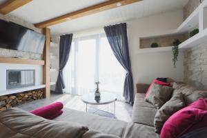 a living room with a couch and a tv at Lotti Residence Exclusiv in Balatonfüred