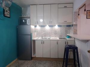 a kitchen with white cabinets and a blue refrigerator at Santa Clara in Almería