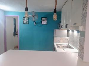 a kitchen with a white counter and a blue wall at Santa Clara in Almería