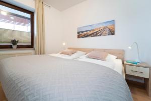 um quarto com uma grande cama branca e uma janela em Strandburg Wohnung 5 em Scharbeutz