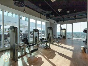 a gym with treadmills and chairs in a room with windows at Luxury 1BR Apt with Unobstructed Dubai Frame View in Dubai