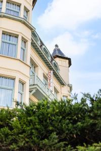 a building with a sign on the side of it at Hotel Georges in Wenduine