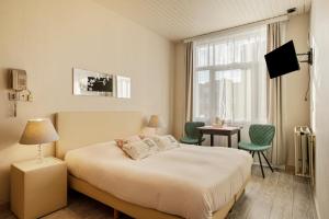 a hotel room with a bed and a window at Hotel Georges in Wenduine
