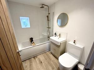 La salle de bains est pourvue de toilettes, d'un lavabo et d'une douche. dans l'établissement Trevose, à Wrexham