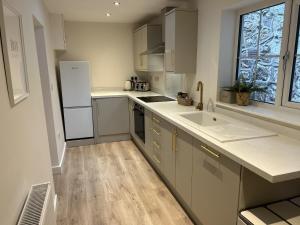 a kitchen with a white refrigerator and a sink at Trevose in Wrexham