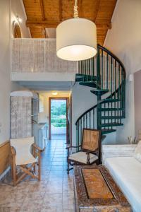 a living room with a spiral staircase and a couch at Villa Del Sol Corfu in Sidari