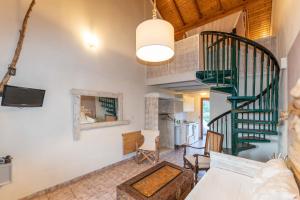 a living room with a spiral staircase and a kitchen at Villa Del Sol Corfu in Sidari