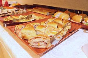 a buffet of sandwiches and pizzas on a table at Klinn Hotel in Tanabi