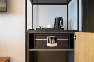 a microwave on a shelf with a coffee maker on it at mk hotel passau in Passau