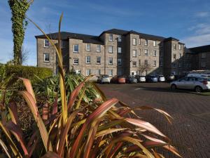 a large building with cars parked in a parking lot at The Waterfront in Greenock