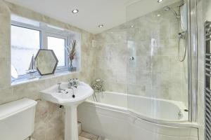 a bathroom with a tub and a sink and a bath tub at Host & Stay - Rose Cottage in Aldbrough