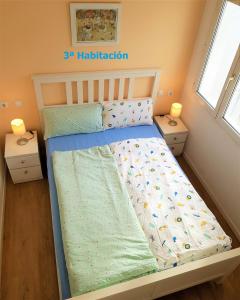 1 cama en una habitación pequeña con 2 mesitas de noche en Vivienda con 3 habitaciones PRÍNCIPE del SILENCIO, en Gijón