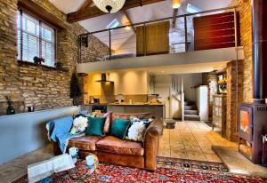 a living room with a couch and a stove at Blacksmith’s Barn - Cosy, Chilled & Dog Friendly. in Wykeham