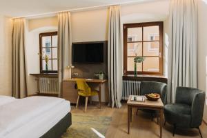 a hotel room with a bed and a desk at Altstadthotel Arch in Regensburg