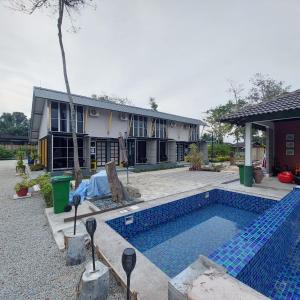 a house with a swimming pool in front of a house at Laman Sakinah Merlimau in Merlimau