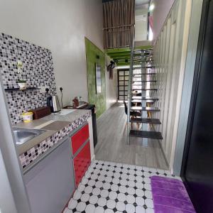 a kitchen with a sink and a staircase in it at Laman Sakinah Merlimau in Merlimau