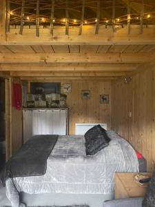 サン・ジャン・ド・モーリエンヌにあるChambre d'Hôtes Kiki & Cocoの木造キャビン内のベッド1台が備わるベッドルーム1室を利用します。