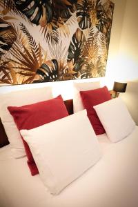 a bedroom with a bed with red and white pillows at Mercure Perpignan Centre in Perpignan