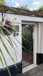 a garage door with a gate with flowers on it at Riverside Cottage in Kent +3 photos