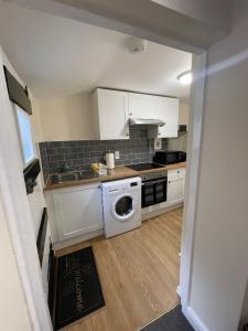 a kitchen with a washer and dryer in a room at Riverside Cottage in Kent