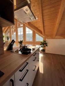 eine Küche mit weißen Schränken und Holzdecken in der Unterkunft Ferienwohnung Blick Thyratal Obergeschoss in Stolberg i. Harz