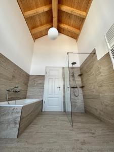 a bathroom with a shower and a bath tub at Ferienwohnung Blick Thyratal Obergeschoss in Stolberg